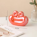 Red glossy ceramic sausage-shaped decorative ornament with cute face detail