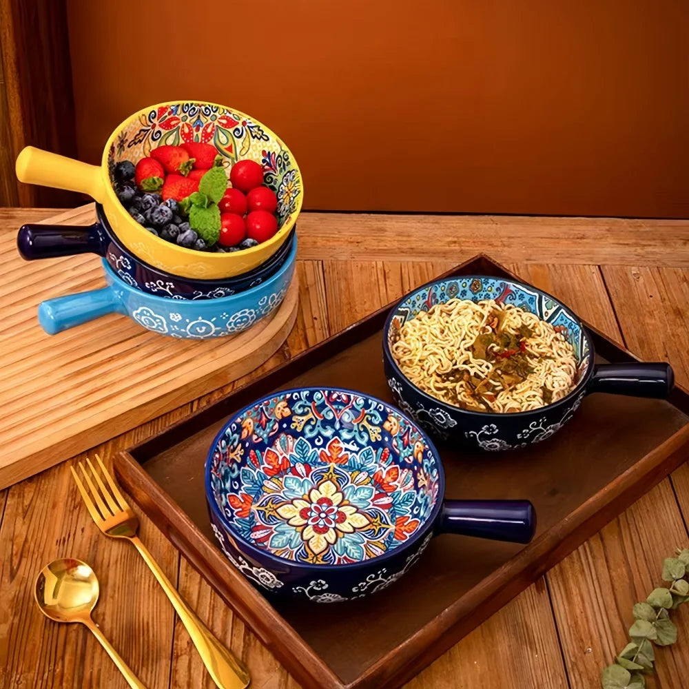 Ceramic salad bowls with floral motifs and colored handles, arranged on wooden tray