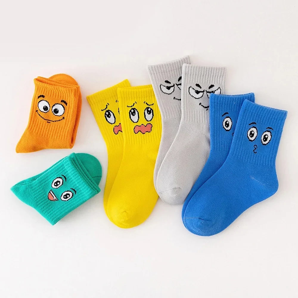 Kids crew socks 5-pair set with cartoon faces in orange, yellow, white, blue, green.