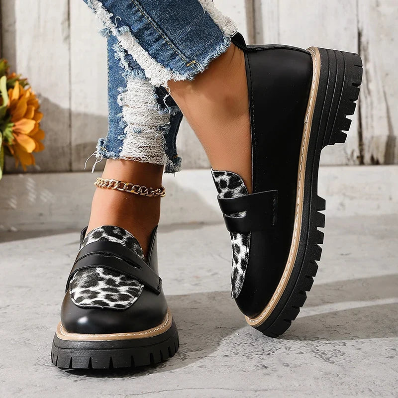 Women’s platform loafers with leopard-print detail, black upper, thick sole, side view