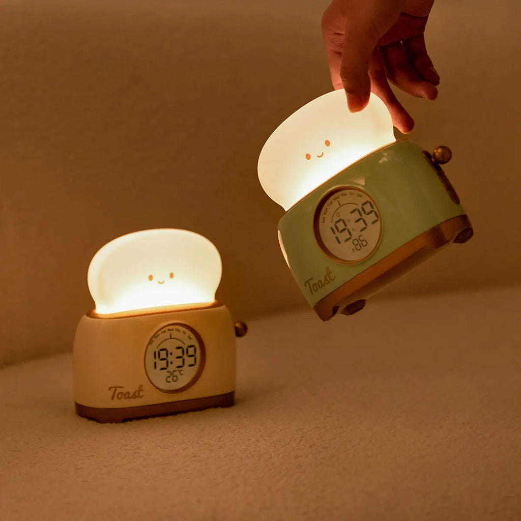 Two toaster night light alarm clocks: small on table and larger being adjusted