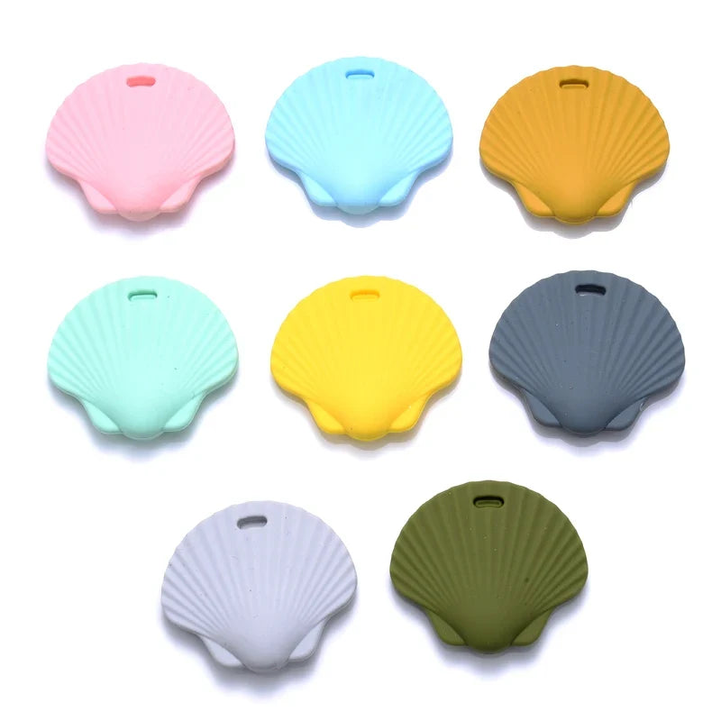 Color options for shell-shaped teether covers in pastel pink, blue, yellow, and gray