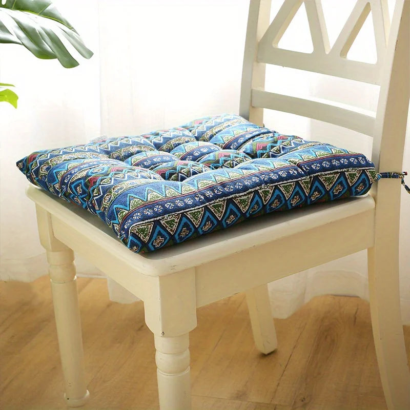 Blue tribal-pattern square seat cushion with carrying strap on chair