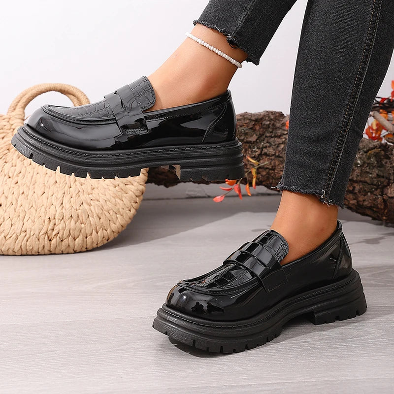 Black patent platform loafer with chunky ridged sole and round toe, slip-on style