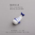 White ceramic fish chopstick holder with blue stripes, small fin tail utensil rest