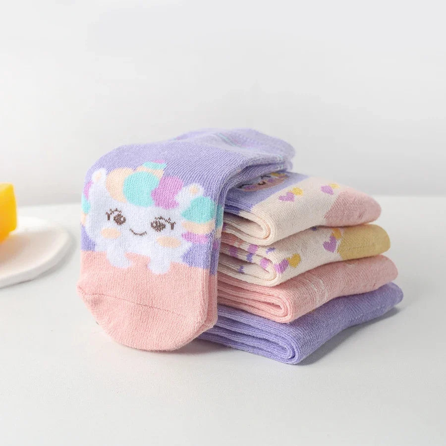 Stack of kids mid-calf socks in lavender and pink with unicorn and cloud prints.