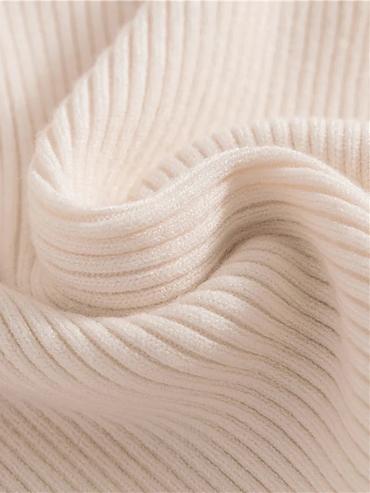 Cream ribbed turtleneck sweater knit close-up, soft texture and folded collar