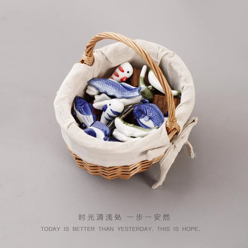 Ceramic fish chopstick holders in a cloth-lined basket, blue-and-white fish shapes