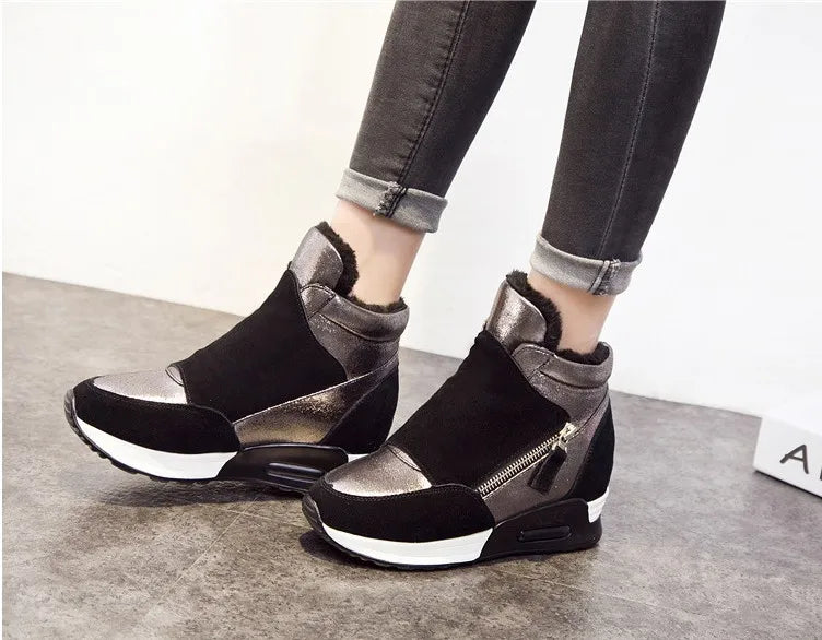 Black ankle boots with faux fur trim, silver panels, and chunky sole