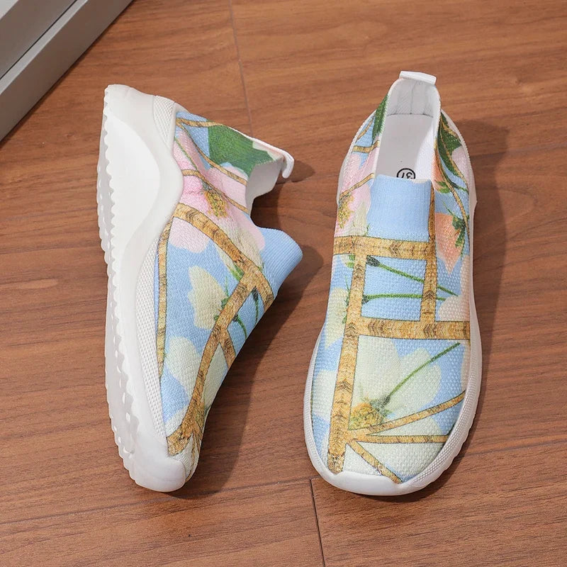 Multicolor knit slip-on sneakers with rounded toe, white outsole, and gold cross strap detail