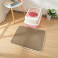 Gray cat litter mat with hex-pattern grid beneath a pink-and-white litter box