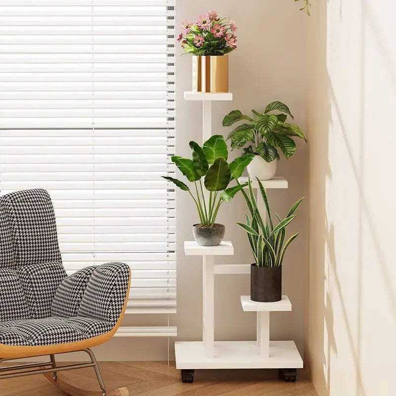 White multi-tier plant stand with potted plants on shelves and caster wheels.