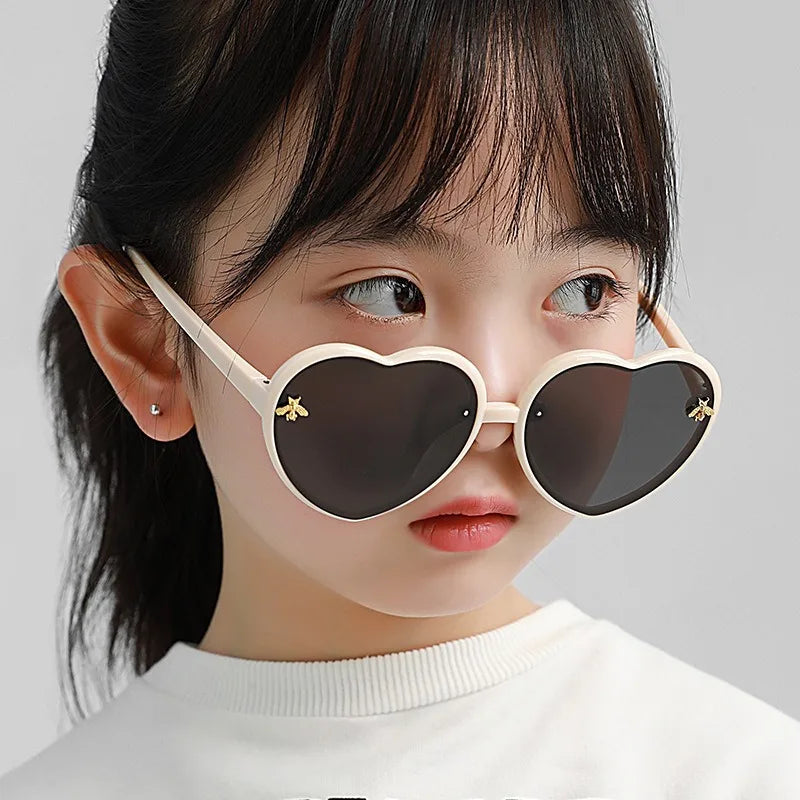 Kids heart sunglasses on child with white frames and dark tint lenses, star charm