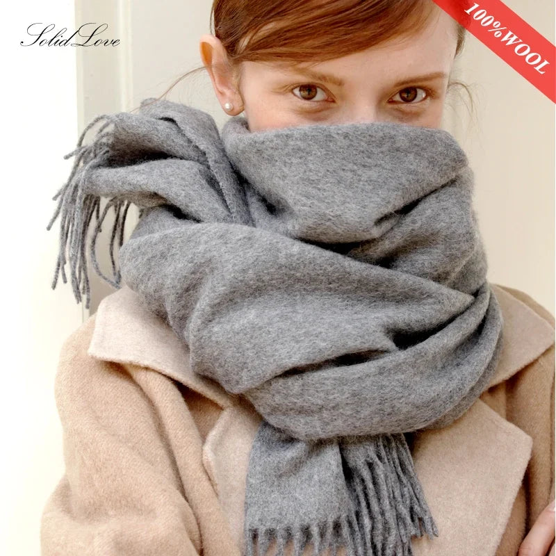 100% wool winter scarf in dark gray with long fringe, wrapped around shoulders