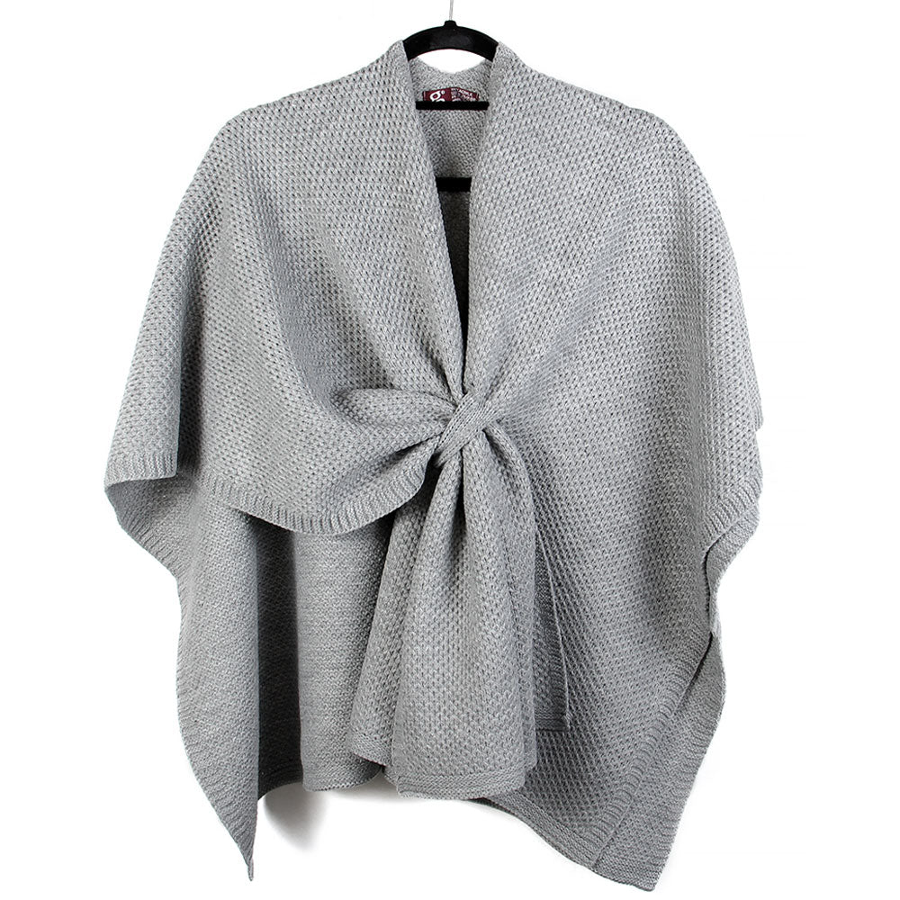 Light gray textured knit wrap shawl poncho with front tie knot, hanging on a black hanger