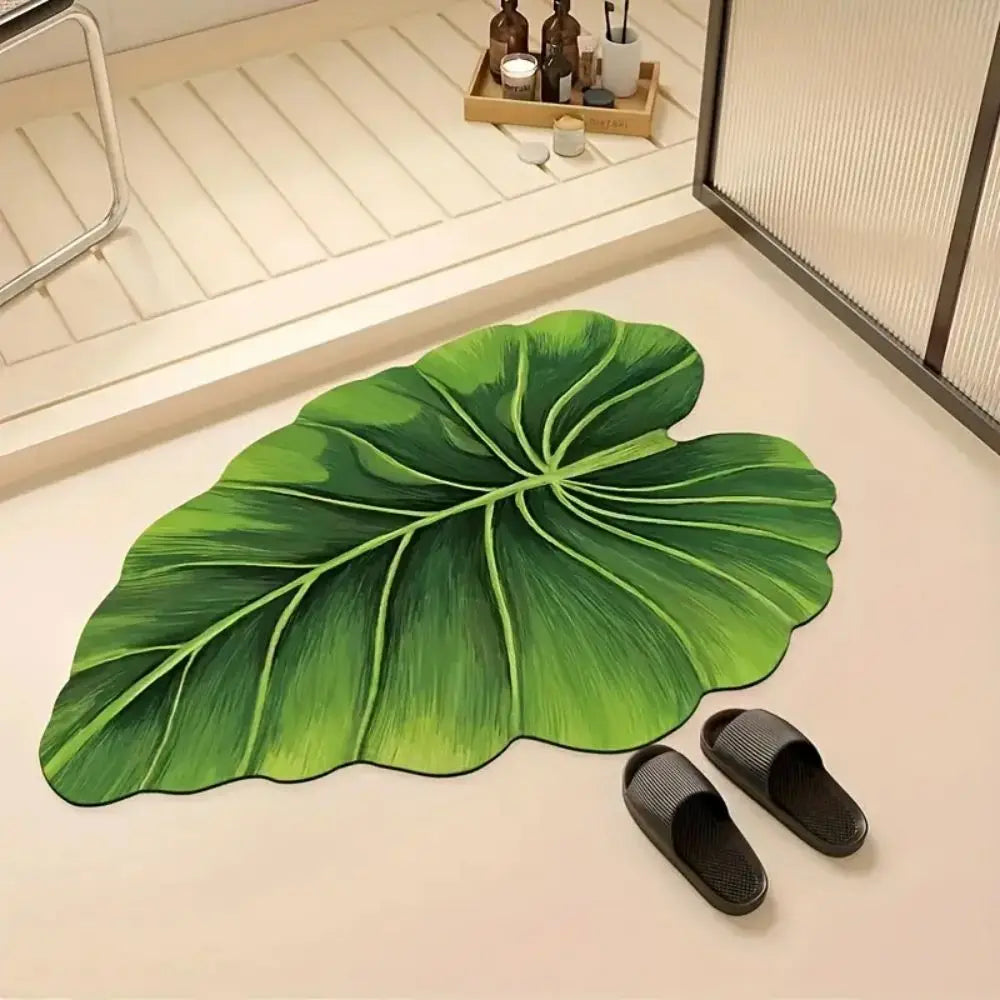 Green leaf-pattern bath mat rug with veining, leaf outline and slippers nearby