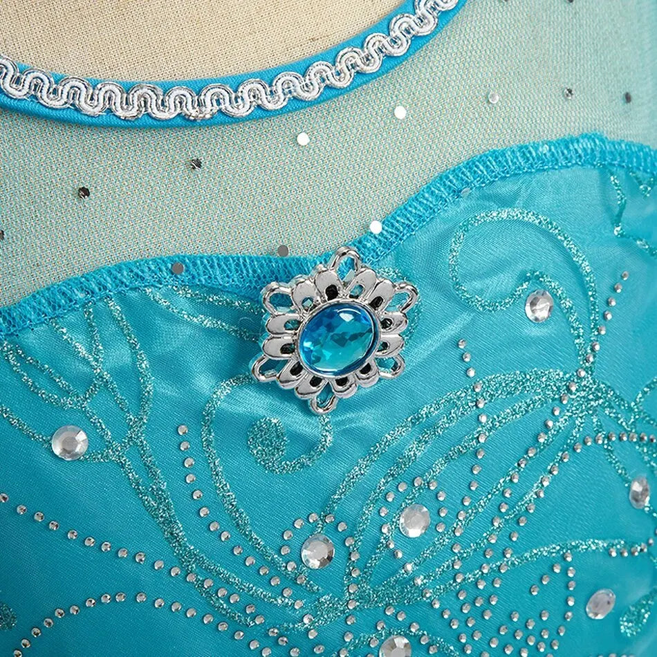Jeweled heart brooch and beaded swirl embroidery on turquoise dress bodice