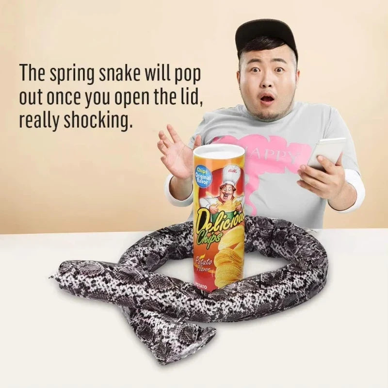 Spring snake prank toy lying coiled on a surface with a chip can.