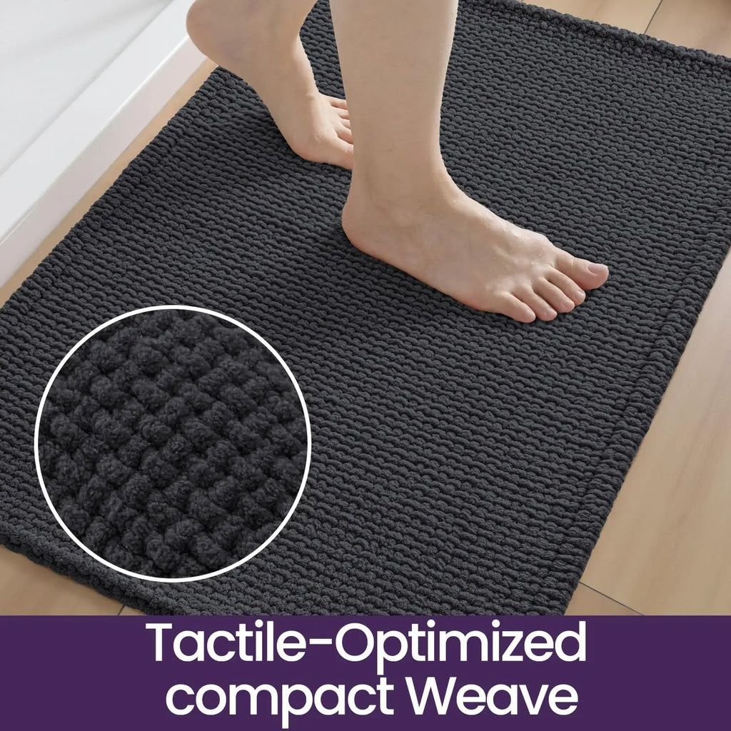 Dark grey textured bath mat underfoot, thick woven surface detail