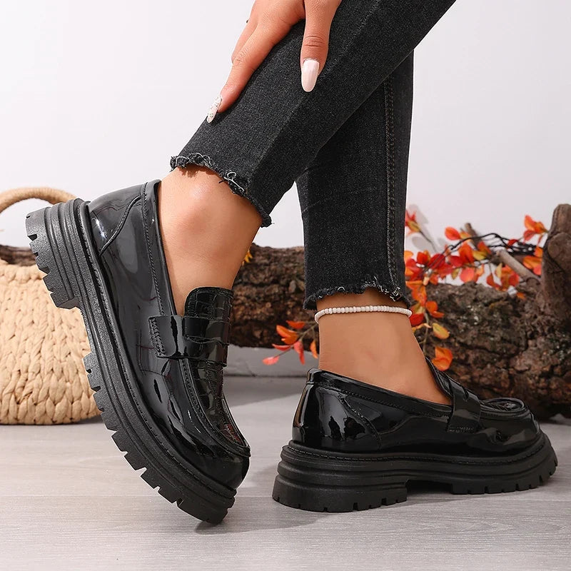 Black patent loafer with glossy finish, chunky platform sole, round toe, slip-on