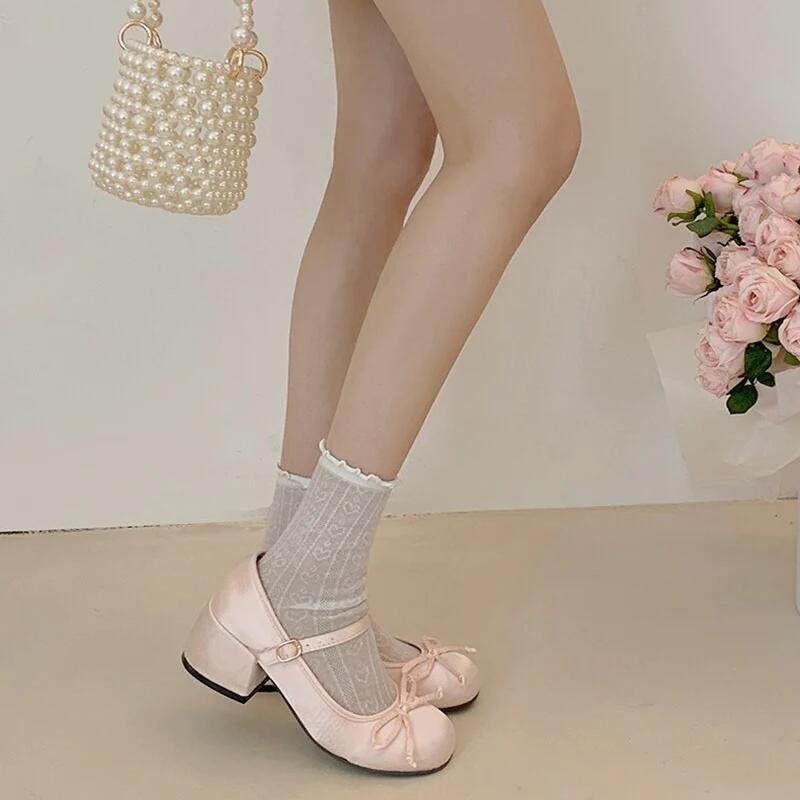 Pink Mary Jane ballet flats with ankle strap and bow, worn with white socks