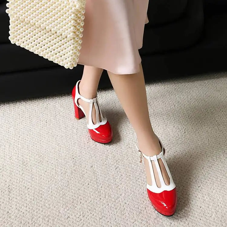 Red-and-white Mary Jane pumps with round toe, T-strap buckle, and square heel.