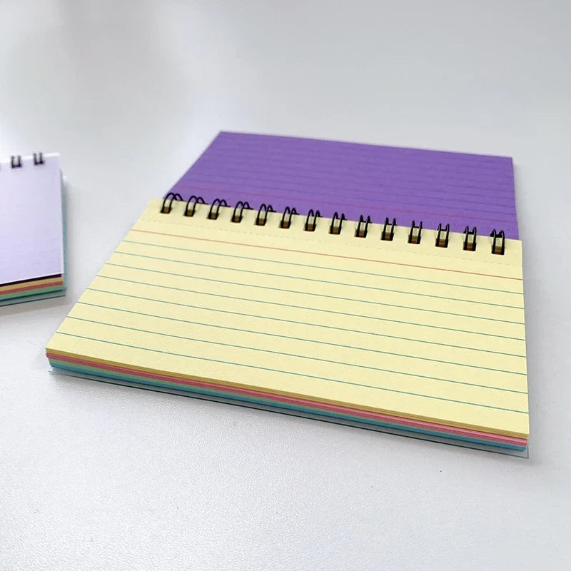 A5 lined spiral notebook stack with cream page and rainbow edge accents