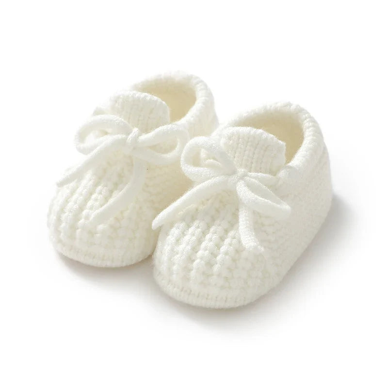 White knitted baby booties with soft lining and bow tie laces