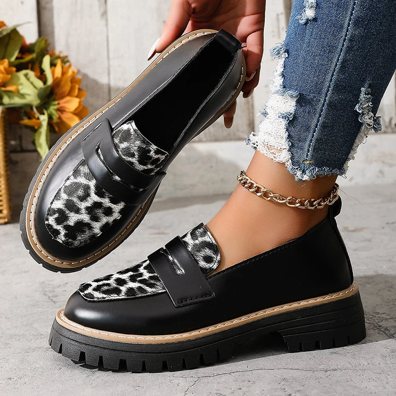 Black and leopard print platform loafers with buckle strap and thick lug sole.