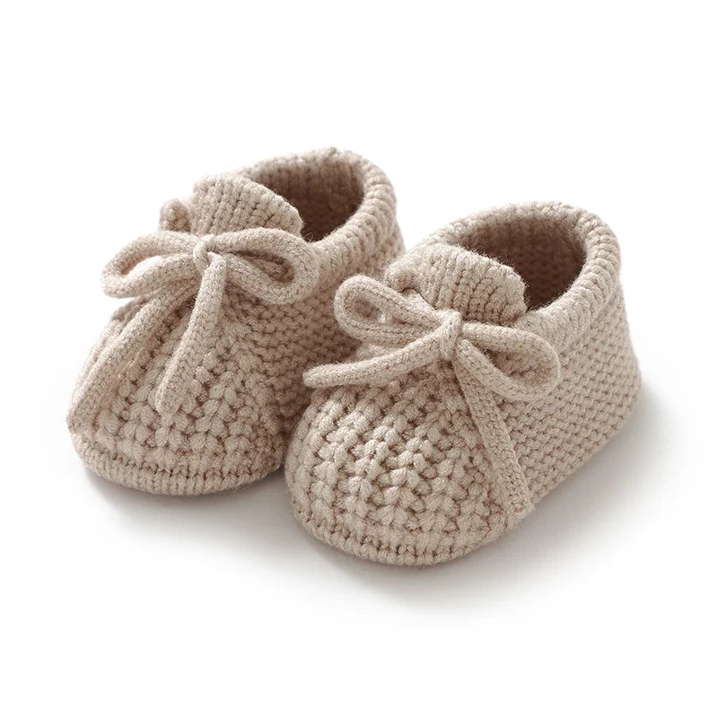 Beige knitted baby booties with soft lining and tie laces
