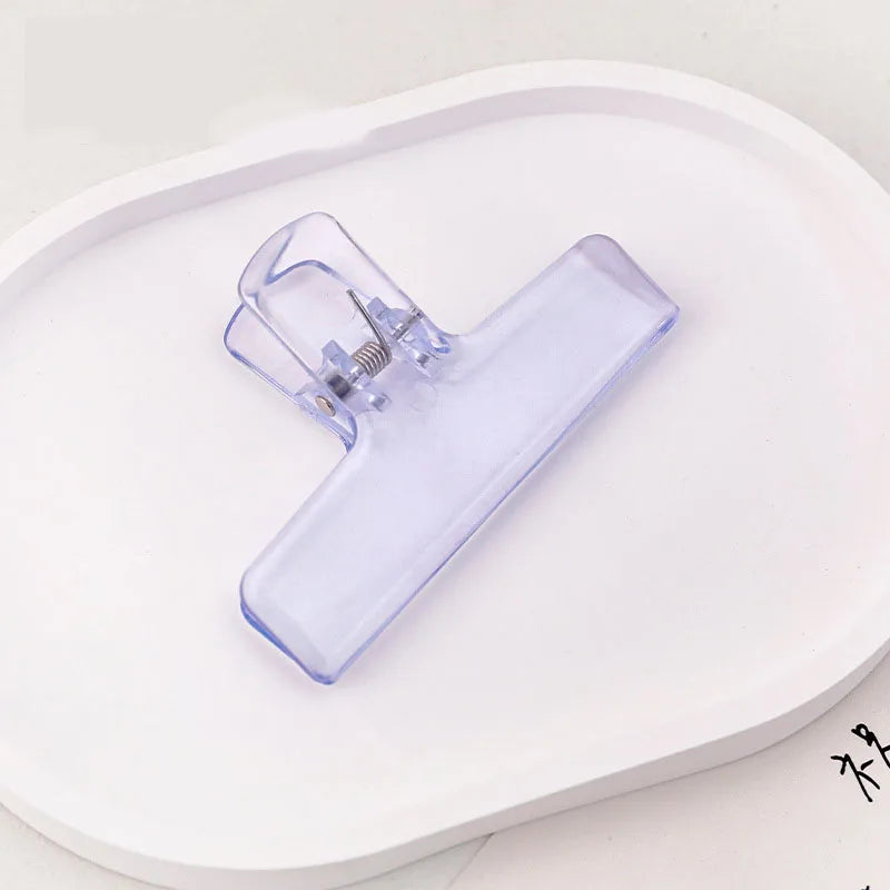Translucent light purple jelly binder clip with spring hinge for organizing papers
