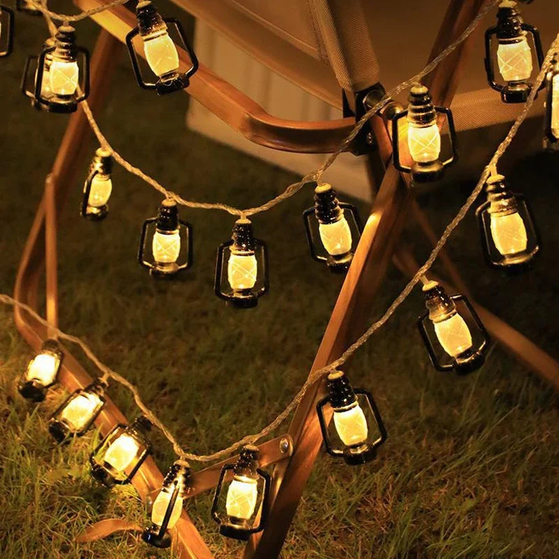 Solar lantern light string with bottle-shaped glass lamps clipped along outdoor tent