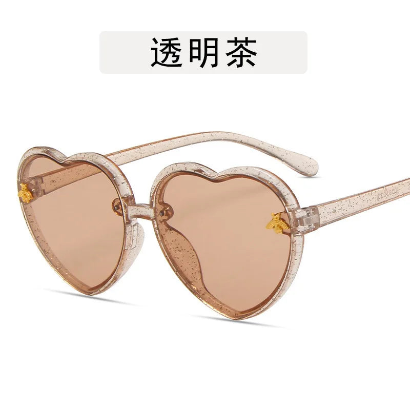 Kids heart-shaped sunglasses with tan frames and clear tint lenses, star details
