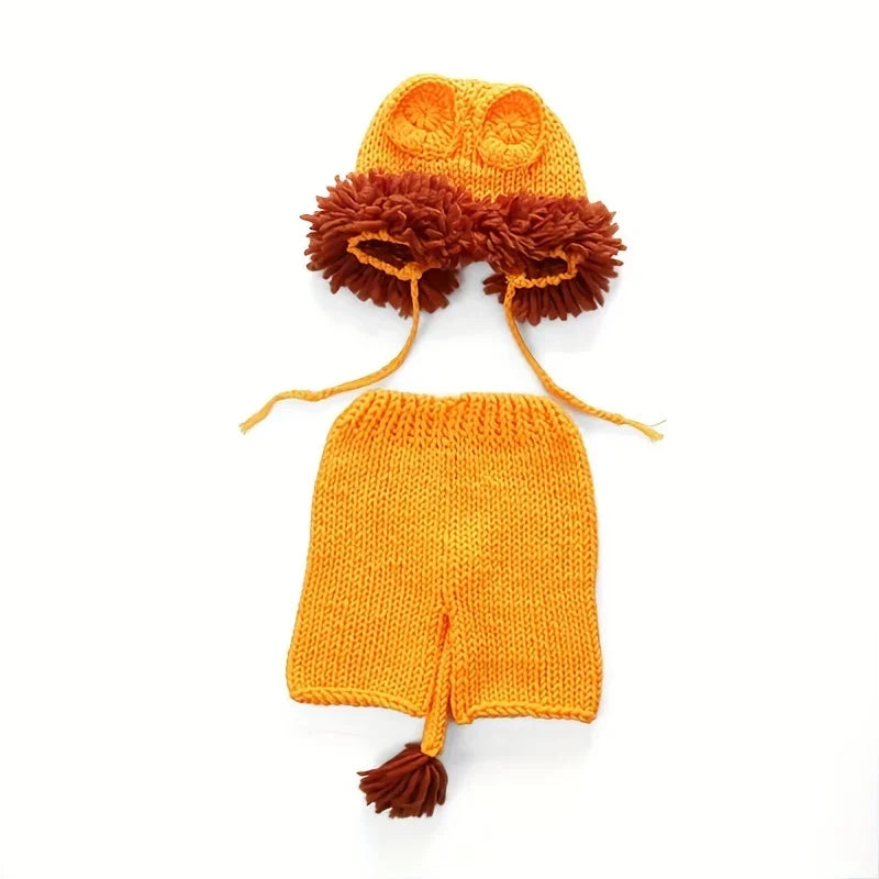 Lion knit beanie and orange shorts with brown pom-pom accents and hanging strings