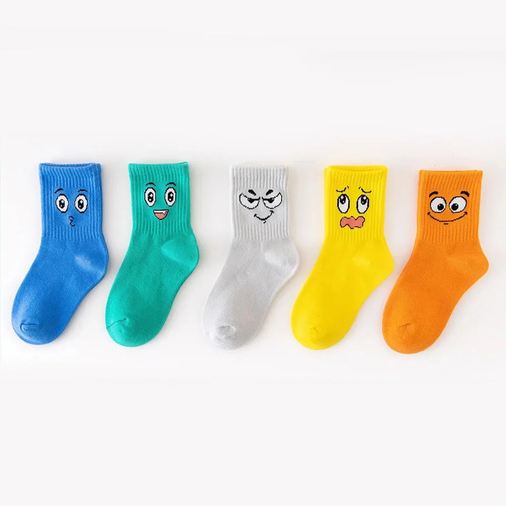 Kids crew socks 5-pair set with cartoon face artwork in blue, teal, white, yellow, orange.