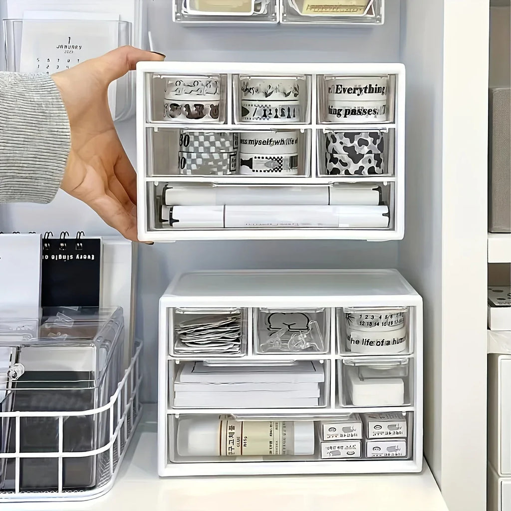 White plastic desk organizer with hand lifting open top drawer and inner storage trays