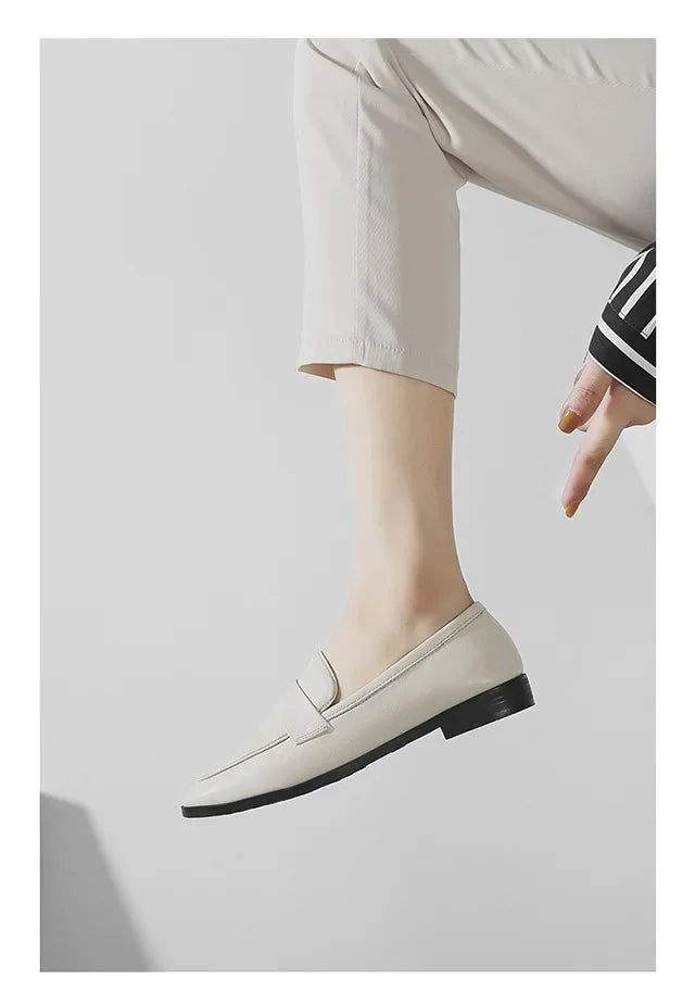 Cream slip-on loafers with rounded toe, worn with light pants