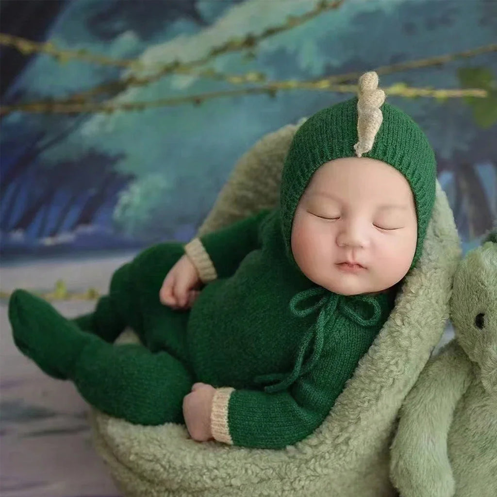 Green dinosaur knit jumpsuit with beige hood and cuff details, newborn size