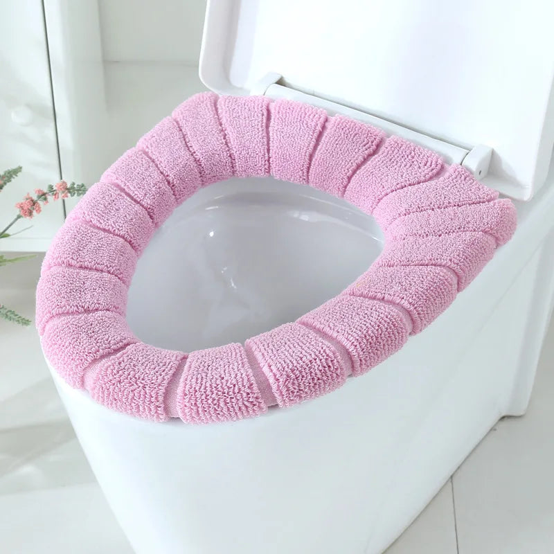 Pink plush toilet seat cover mat fitted on a toilet seat