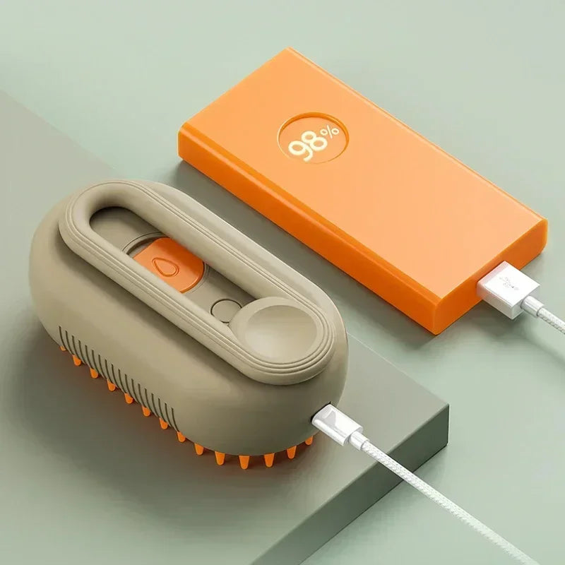 Electric steam pet brush with charging cable, beige base unit and orange accessory