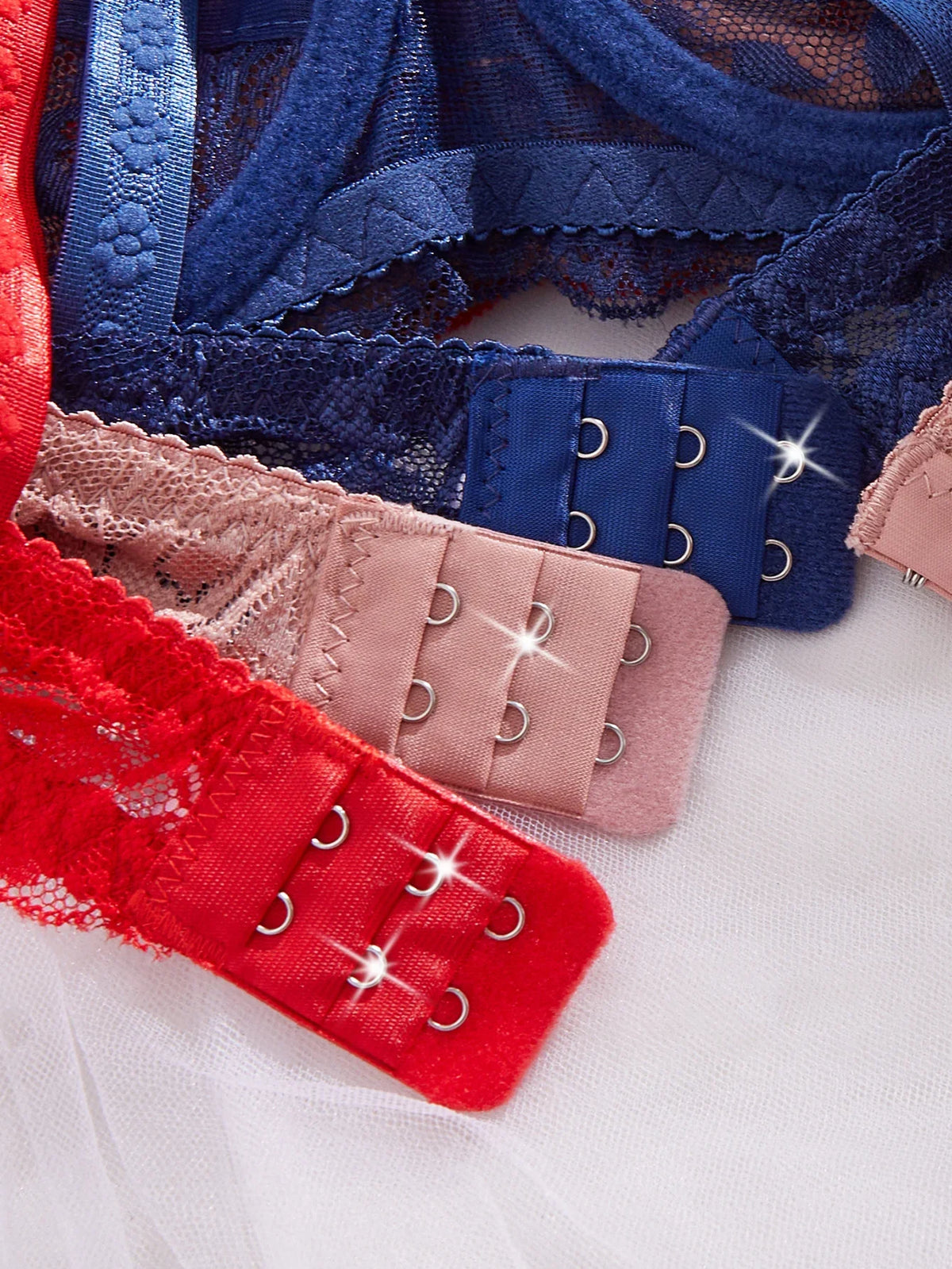 Lace bra bands with hook-and-eye closures in dark blue, pink, and red
