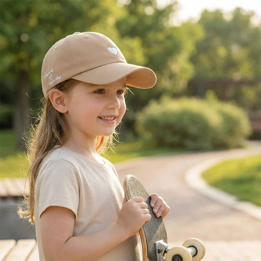 Kids ponytail baseball cap, beige cotton with small heart patch on front