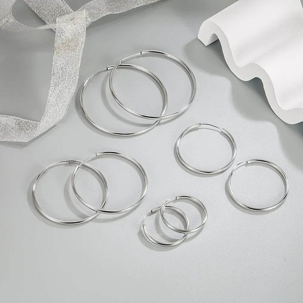 Silver thick hoop earrings set laid out, round hoops in different sizes