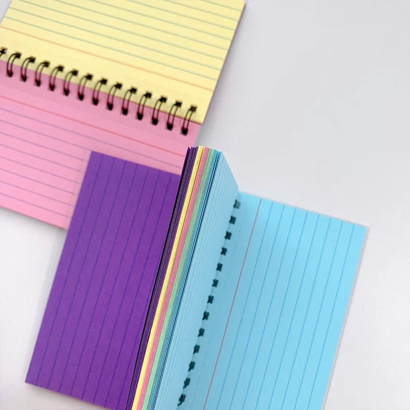A5 lined spiral notebook open, showing rainbow inner spine and page lines