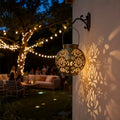 Bronze iron hanging solar lantern with carved globe cutouts, warm projected pattern