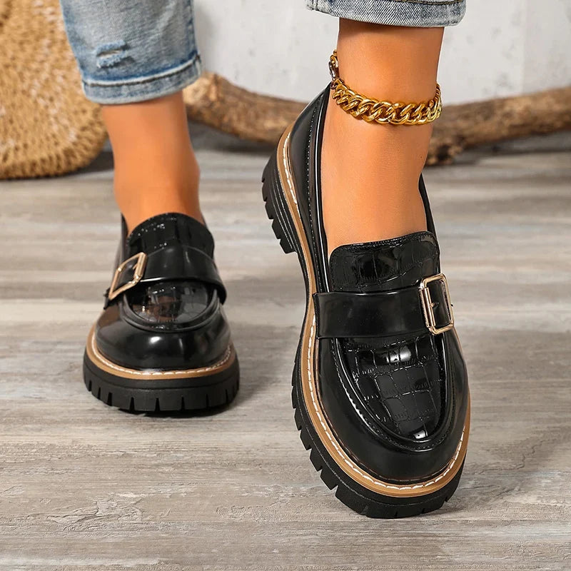 Black patent loafers with buckle strap and thick platform sole, side and heel view