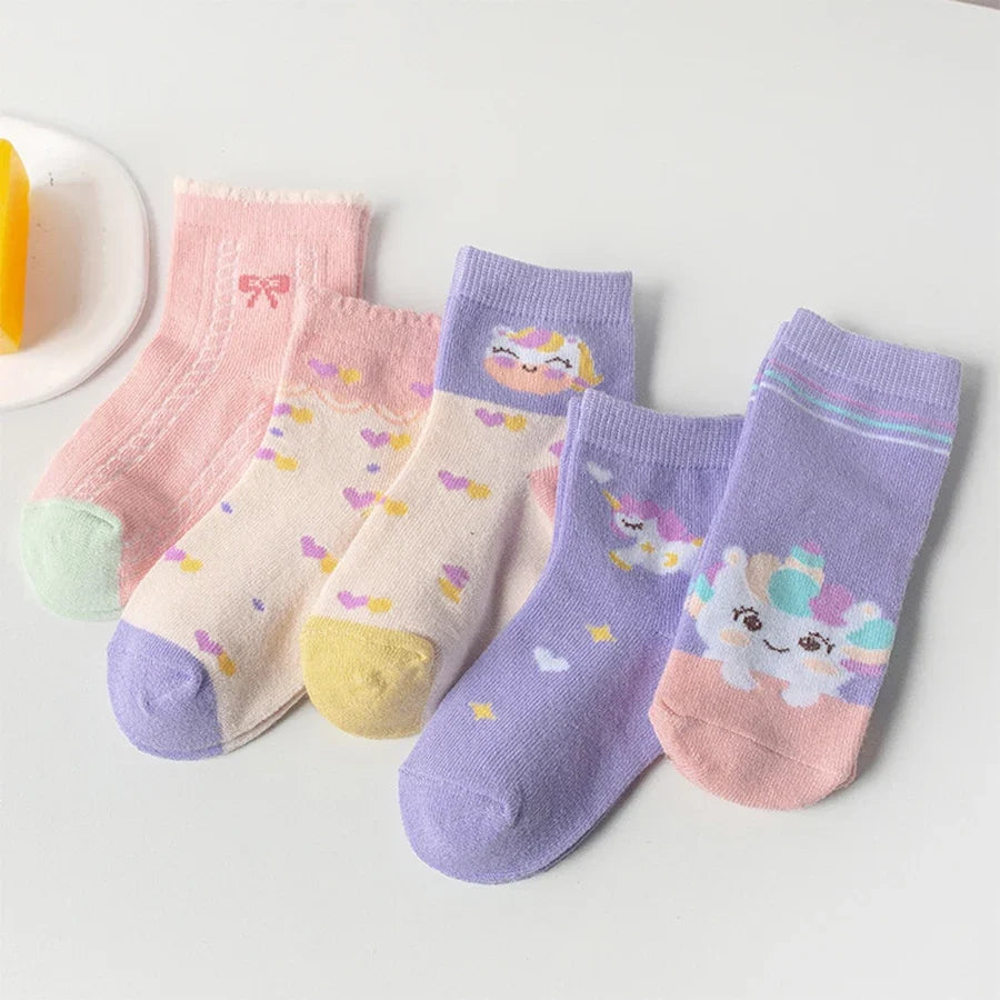 Five pairs of kids mid-calf socks in lavender, pink, and cream with unicorn prints.