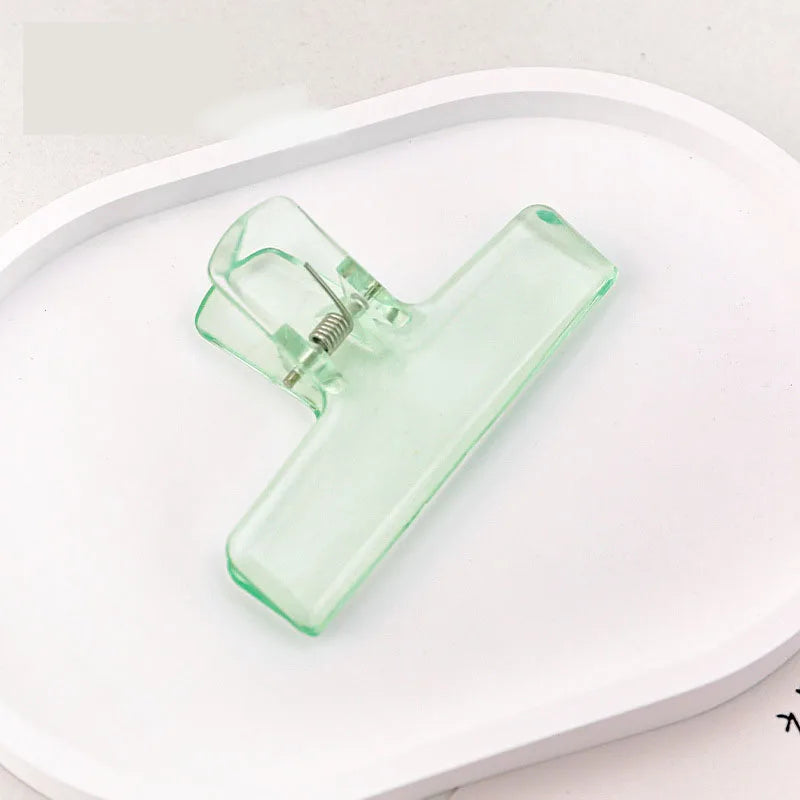 Translucent green jelly binder clip with spring hinge for organizing papers