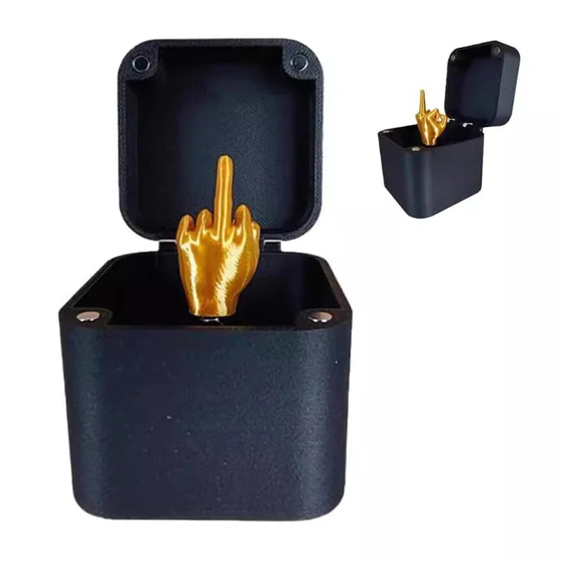 Black prank container open with a gold finger-shaped spring toy inside.
