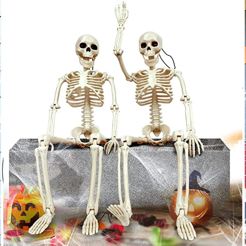 Pair of white skeleton humanoid decorations posed on a stone ledge